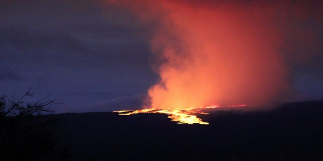 Lava pours out of the summit crater of Mauna Loa about 6:35 a.m. Monday, Nov. 28, 2022, as seen from Gilbert Kahele Recreation Area on Maunakea, Hawaii. Mauna Loa, the world’s largest active volcano, began spewing ash and debris from its summit, prompting civil defense officials to warn residents on Monday to prepare in case the eruption causes lava to flow toward communities.