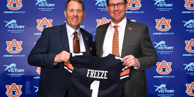 El entrenador de fútbol americano de Auburn, Hugh Freeze, a la izquierda, y el director atlético John Cohen posan durante una conferencia de prensa el martes 29 de noviembre de 2022 en Auburn, Alabama.