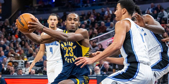 Indiana Pacers forward Aaron Nesmith dribbles the ball against Orlando Magic forward Caleb Houstan at Gainbridge Fieldhouse, Nov. 19, 2022, in Indianapolis.