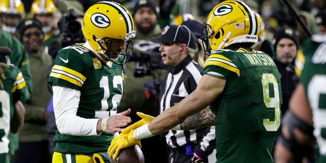 Green Bay Packers' Aaron Rodgers (12) and Christian Watson celebrate after hooking up for a touchdown during the second half against the Dallas Cowboys, Nov. 13, 2022, in Green Bay, Wisconsin.