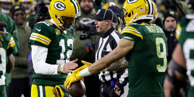 Green Bay Packers' Aaron Rodgers, #12, and Christian Watson, #9, celebrate after hooking up for a touchdown during the second half of an NFL football game against the Dallas Cowboys Sunday, Nov. 13, 2022, in Green Bay, Wisconsin.