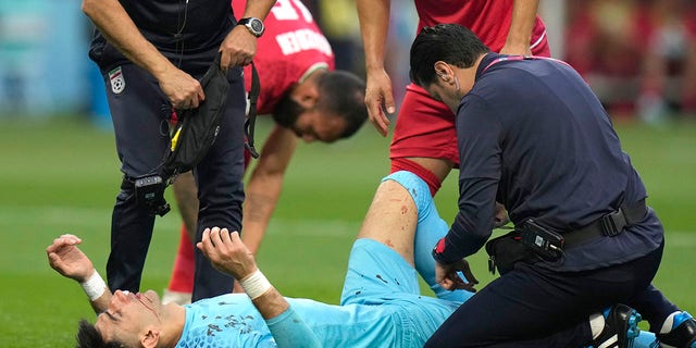 Iran's goalkeeper Alireza Beiranvand lies on the ground after he was injured during the World Cup group B soccer match between England and Iran at the Khalifa International Stadium in Doha, Qatar, Monday, Nov. 21, 2022.