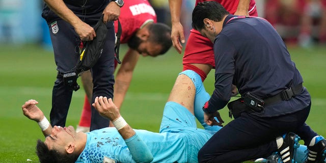 Iran's goalkeeper Alireza Beiranvand lies on the ground after he was injured during the World Cup group B soccer match between England and Iran at the Khalifa International Stadium in Doha, Qatar, Monday, Nov. 21, 2022.