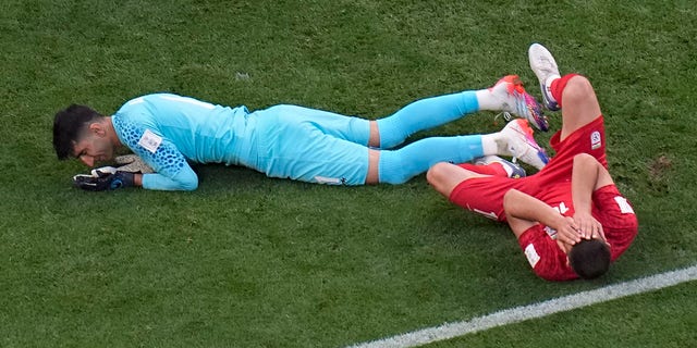 Iran's Majid Hosseini, right, in pain after colliding with goalkeeper Alireza Beiranvand, left, during the World Cup group B soccer match between England and Iran at the Khalifa International Stadium in Doha, Qatar, Monday, Nov. 21, 2022. 