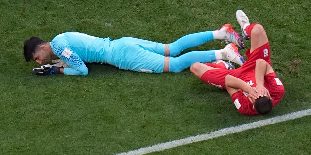 Iran's Majid Hosseini, right, in pain after colliding with goalkeeper Alireza Beiranvand, left, during the World Cup group B soccer match between England and Iran at the Khalifa International Stadium in Doha, Qatar, Monday, Nov. 21, 2022. 