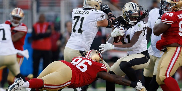 New Orleans Saints running back Alvin Kamara, right, runs against San Francisco 49ers defensive tackle TY McGill, #96, during the first half of an NFL football game on Sunday, Nov. 27, 2022, in Santa Clara, California. 