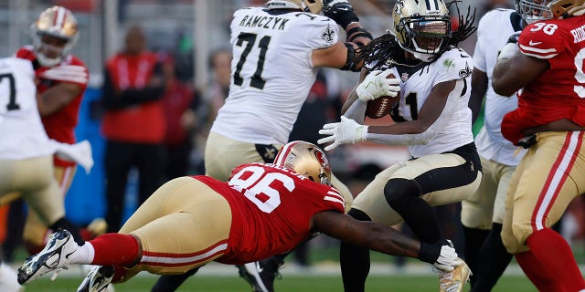 New Orleans Saints running back Alvin Kamara, right, runs against San Francisco 49ers defensive tackle TY McGill, #96, during the first half of an NFL football game on Sunday, Nov. 27, 2022, in Santa Clara, California. 