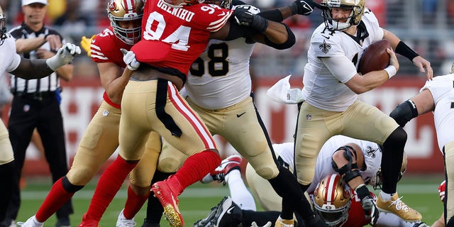 New Orleans Saints quarterback Andy Dalton, right, runs from San Francisco 49ers defensive end Charles Omenihu (94) during the first half of an NFL football game in Santa Clara, California, on Sunday, November 27, 2022.