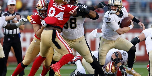 New Orleans Saints quarterback Andy Dalton, right, runs from San Francisco 49ers defensive end Charles Omenihu (94) during the first half of an NFL football game in Santa Clara, California, on Sunday, November 27, 2022.