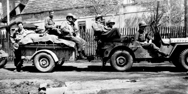 Andy Andrews, far left, and his squad with his Jeep in Europe.