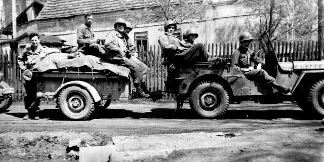 Andy Andrews, far left, and his squad with his Jeep in Europe.