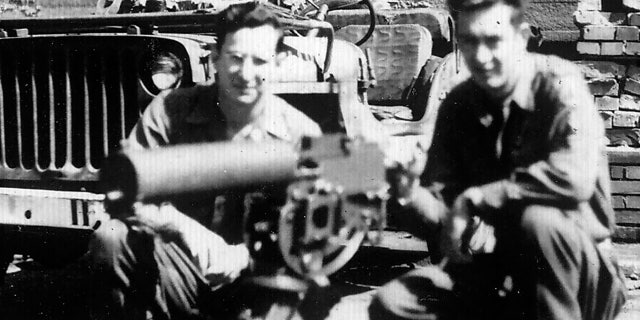 Andy Andrews, left, and a fellow soldier with a machine gun and a jeep.