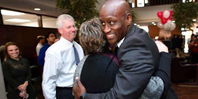 Charles Robinson, right, is congratulated by associates after being hired as the chancellor of the University of Arkansas during a reception at the university's administration building on Nov. 16, 2022, in Fayetteville, Arkansas.