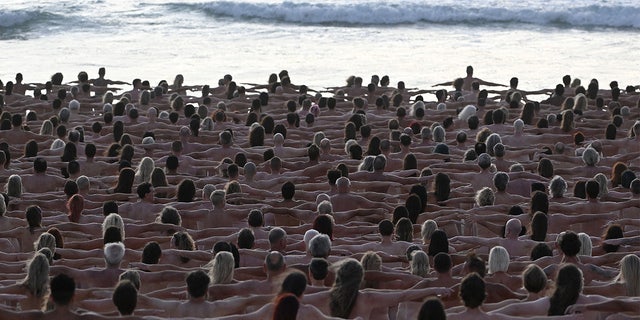 Participants pose nude during sunrise on Sydney's Bondi Beach for US art photographer Spencer Tunick, to raise awareness for skin cancer, on November 26, 2022.