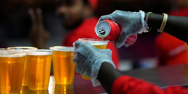 Staff member pours a beer at a fan zone ahead of the FIFA World Cup, in Doha, Qatar Saturday, Nov. 19, 2022.
