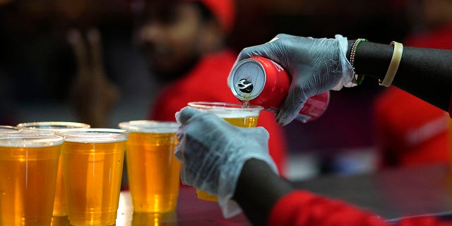 Staff member pours a beer at a fan zone ahead of the FIFA World Cup, in Doha, Qatar Saturday, Nov. 19, 2022.