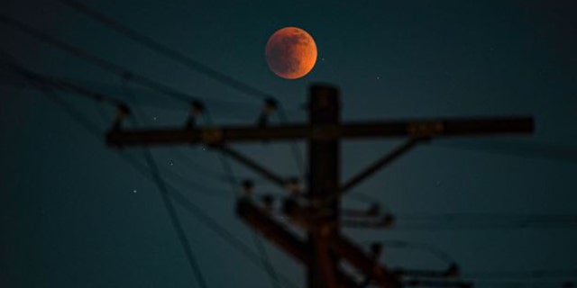 A blood moon lunar eclipse seen in the sky.