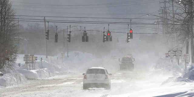 Cars drive through snow on McKinley Parkway in Erie County, New York, on Nov. 20, 2022. A Buffalo city employee was fatally struck by heavy equipment that was removing snow from the road following the storm.