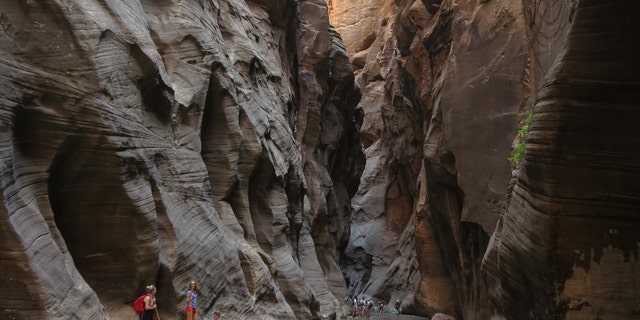 Visitantes exploram The Narrows ao longo do Virgin River em 15 de julho de 2014, no Zion National Park, Utah.  O Zion National Park está entre os maiores destinos turísticos do estado. 