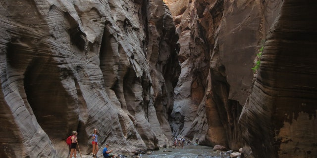 Visitors explore The Narrows along the Virgin River on July 15, 2014, in Zion National Park, Utah. Zion National Park is among the state's biggest tourist destinations. 