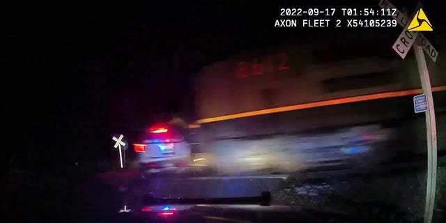 A screenshot of police body camera footage shows the moment a train hits a police car parked on the tracks with Yareni Rios-Gonzalez detained in the backseat.