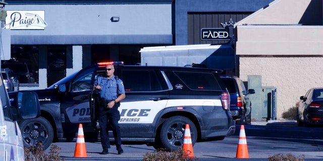 A police officer exits his car near a crime scene at a gay nightclub in Colorado Springs, Colo., Sunday, Nov. 20, 2022 where a shooting occurred late Saturday night.