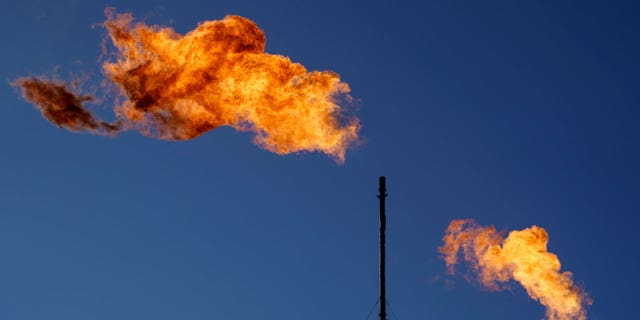Flares burn off methane and other hydrocarbons at an oil and gas facility in Lenorah, Texas on Oct. 15, 2021.