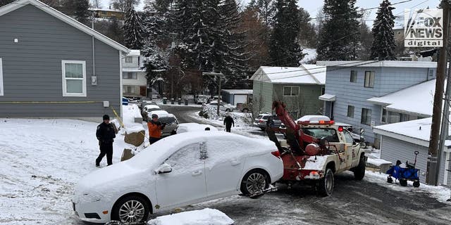 A white sedan is towed away from a home where four University of Idaho students were murdered two weeks ago. 