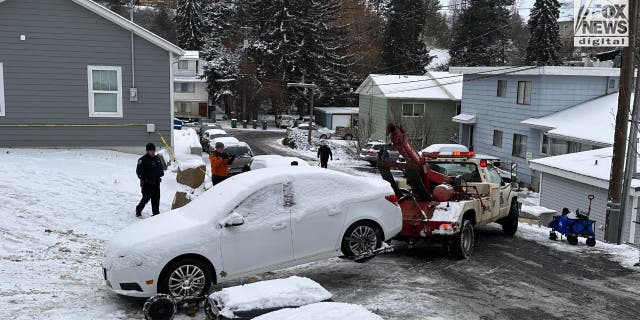 A white sedan is towed away from a home where four University of Idaho students were murdered two weeks ago. 