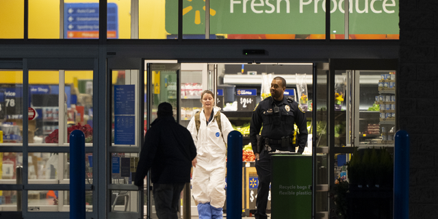 A law enforcement detective wears protective coverings as they work at the scene of a mass shooting at a Walmart, on Nov. 23, in Chesapeake, Virginia.