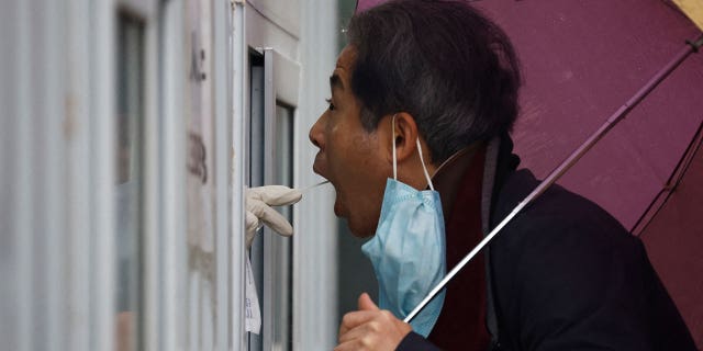 A man has his swab sample taken for nucleic acid test for the coronavirus disease at a testing booth, in Beijing, China on Nov. 11, 2022.