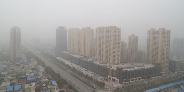 In China's city Tai'an, an attempted bank robbery began around noon on Tuesday and local police shot the suspect and freed the hostage he had taken. Police said no one else was harmed. Pictured: Heavy smog covering the city buildings on Nov. 10, 2015, in Taian, Shandong Province of China.