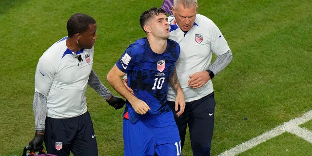 Christian Pulisic, of the United States, is helped by team doctors after he scored USA's opening goal during the World Cup Group B soccer match between Iran and the United States at the Al Thumama Stadium in Doha, Qatar, Tuesday, Nov. 29, 2022.