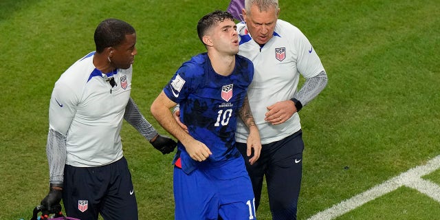 Christian Pulisic of the United States receives help from team doctors after scoring the first goal for the United States during the World Cup Group B soccer match between Iran and the United States at Al Thumama Stadium in Doha, Qatar, on Tuesday, November 29, 2022. . 