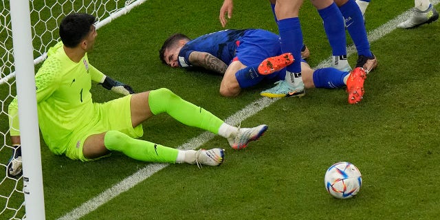 Christian Pulisic of the United States clashes with Iran's goalkeeper Alireza Beiranvand after he scoring his side's opening goal during the World Cup group B soccer match between Iran and the United States at the Al Thumama Stadium in Doha, Qatar, Tuesday, Nov. 29, 2022. 