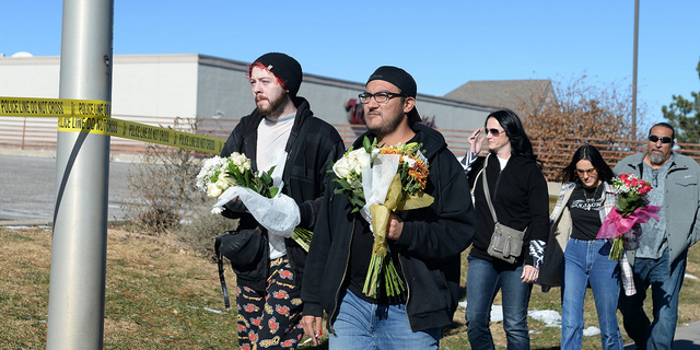 Tim Bates, Erric Ramirez, Malissa Ramirez, Trinity Ramirez, and Fred Ramirez deliver flowers near a gay nightclub in Colorado Springs, Colorado, on Sunday, Nov. 20, where a shooting occurred late Saturday night.