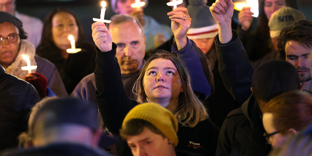 People hold a vigil at a makeshift memorial near the Club Q nightclub on Nov. 20, 2022, in Colorado Springs, Colorado.