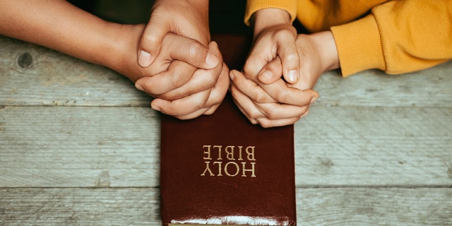 Indiana pastor challenges US faith leaders to sign pledge in face of wokeism: Preach 'one true gospel' only 5 couple praying with bible