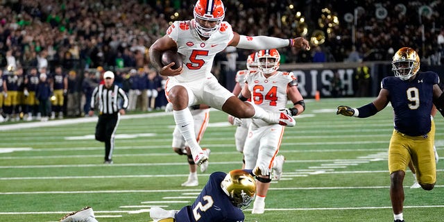 Clemson quarterback DJ Uiagalelei hurdles Notre Dame safety DJ Brown during the second half of an NCAA college football game Saturday, Nov. 5, 2022, in South Bend, Ind. Notre Dame won 35-14.