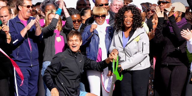 Dr. Mehmet Oz and media personality Oprah Winfrey cut the ribbon to signal the start of the "Live Your Best Life Walk" to celebrate O, The Oprah Magazine's 10th Anniversary at Intrepid Welcome Center on May 9, 2010, in New York City.