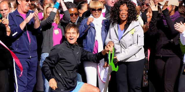 Dr. Mehmet Oz and media personality Oprah Winfrey cut the ribbon to signal the start of the "Live Your Best Life Walk" to celebrate O, The Oprah Magazine's 10th Anniversary at Intrepid Welcome Center on May 9, 2010, in New York City.