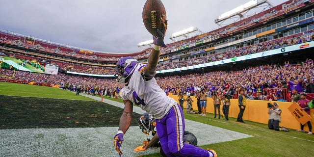 Minnesota Vikings running back Dalvin Cook (4) holds up the ball after making a touchdown catch against the Washington Commanders during the second half on Nov. 6, 2022, in Landover, Maryland.