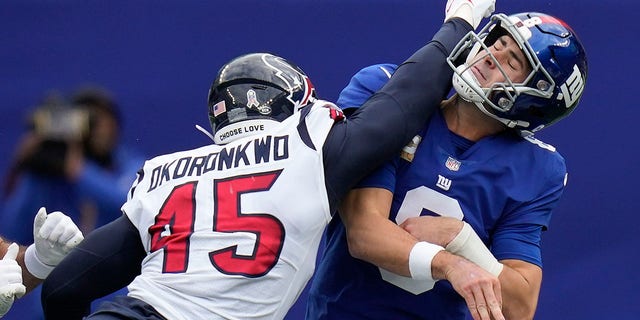 New York Giants quarterback Daniel Jones takes a hit from Houston Texans linebacker Ogbonnia Okoronkwo, Sunday, Nov. 13, 2022, in East Rutherford, New Jersey.