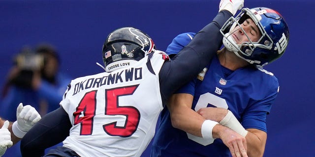 New York Giants quarterback Daniel Jones takes a hit from Houston Texans linebacker Ogbonnia Okoronkwo, Sunday, Nov. 13, 2022, in East Rutherford, New Jersey.