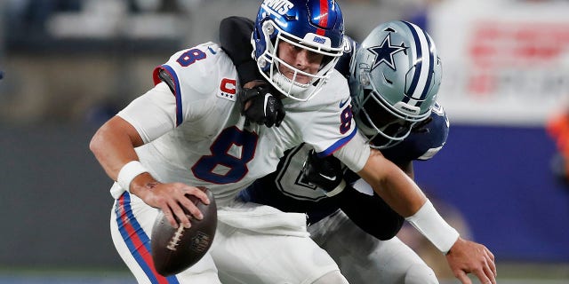 Daniel Jones (8) z New York Giants zostaje pokonany przez Donovan Wilson z Dallas Cowboys, gdy Cowboys pokonali Giants 23-16 na stadionie MetLife w East Rutherford, NJ, 26 września 2022 r.