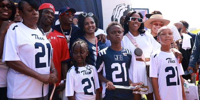 JACKSON, MISSISSIPPI SEPTEMBER 17: Coach Deion Sanders takes a photo with the family of slain Hip Hop artist Young Dolph prior to the kick off of the game against Grambling State.