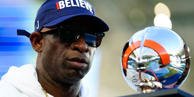 Jackson State Tigers head coach Deion Sanders receives the Orange Blossom Classic Trophy after beating the Florida A and M Rattlers at Hard Rock Stadium in Miami, Fla., Sept. 4, 2022.