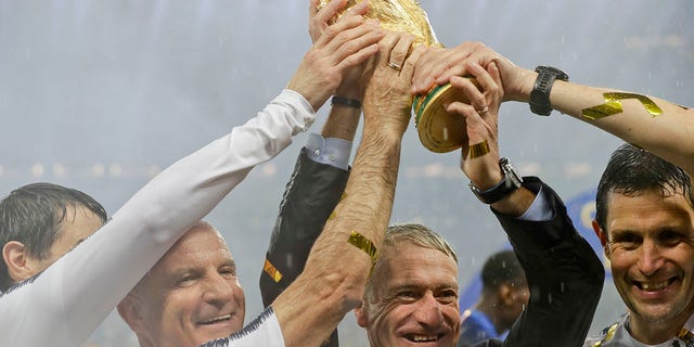 FILE - In this Sunday, July 15, 2018 file photo, France head coach Didier Deschamps, second right, holds the trophy at the end of the final match between France and Croatia at the 2018 soccer World Cup in the Luzhniki Stadium in Moscow, Russia.