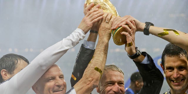 FILE - In this Sunday, July 15, 2018 file photo, France head coach Didier Deschamps, second right, holds the trophy at the end of the final match between France and Croatia at the 2018 soccer World Cup in the Luzhniki Stadium in Moscow, Russia.
