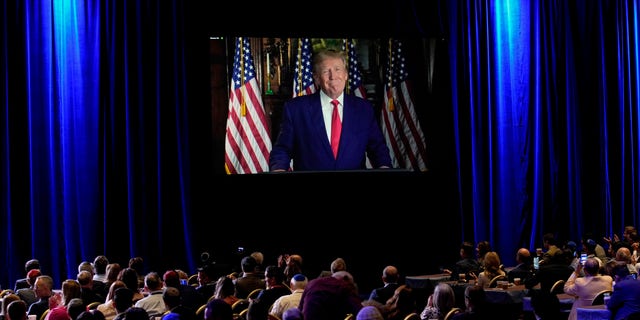 People listen as former President Trump speaks remotely to an annual leadership meeting of the Republican Jewish Coalition Saturday, Nov. 19, 2022, in Las Vegas. 